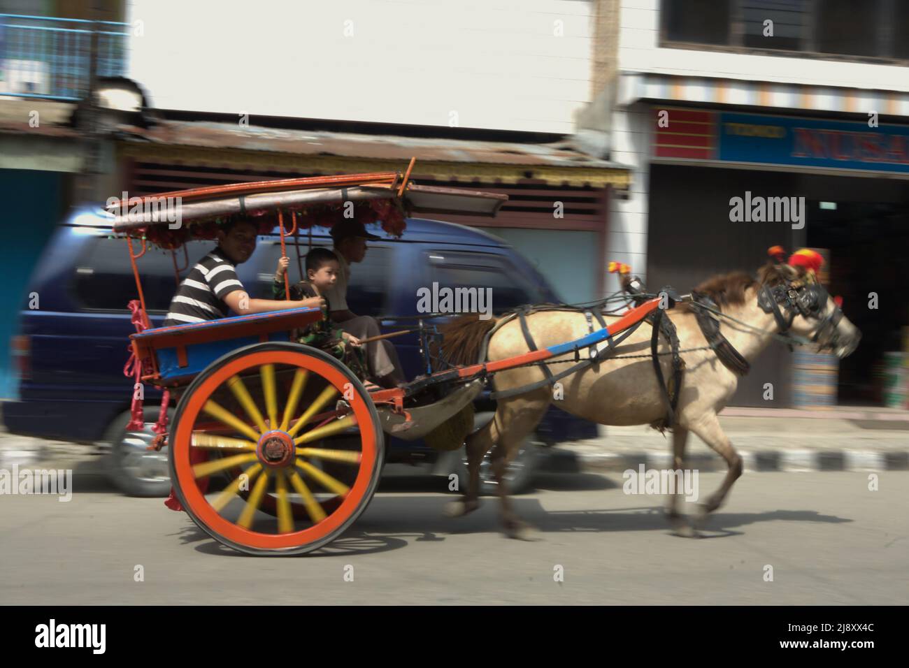 Horse Riding Rickshaw A horse-pulled rickshaw carrying passengers, moving on a road in Sungai ...