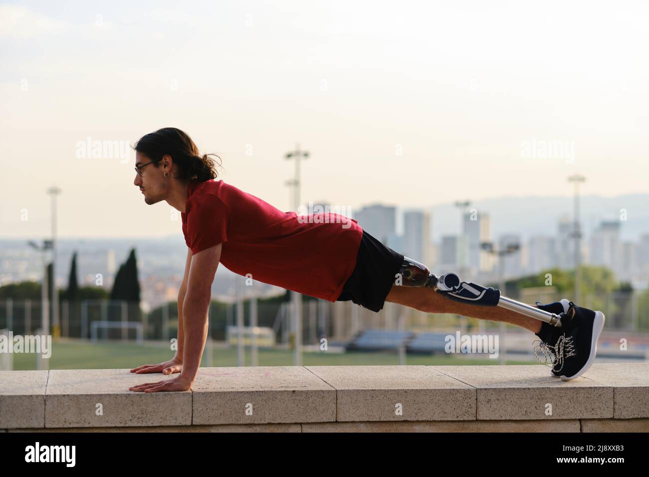 Athletic man with a disability doing push ups while working out. Stock Photo