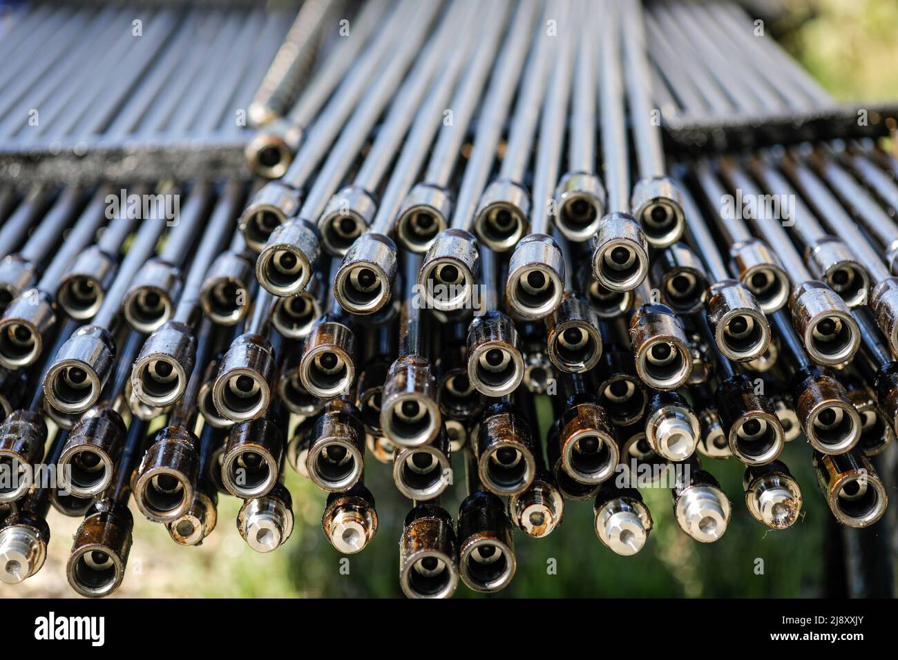 Oil rig drill pipes stacked with oil industry workers in the background