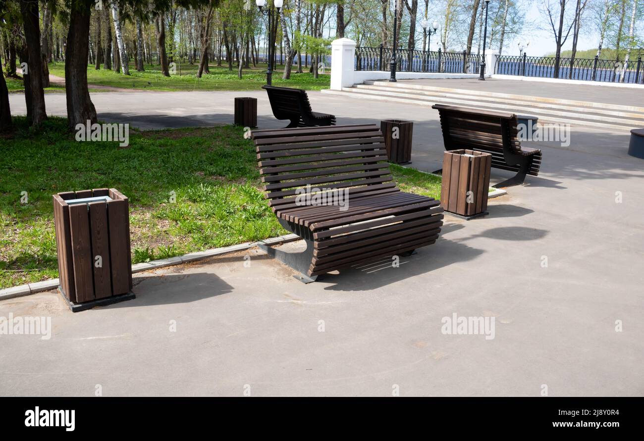 Wooden brown bench in the city park on a bright spring day. Stock Photo