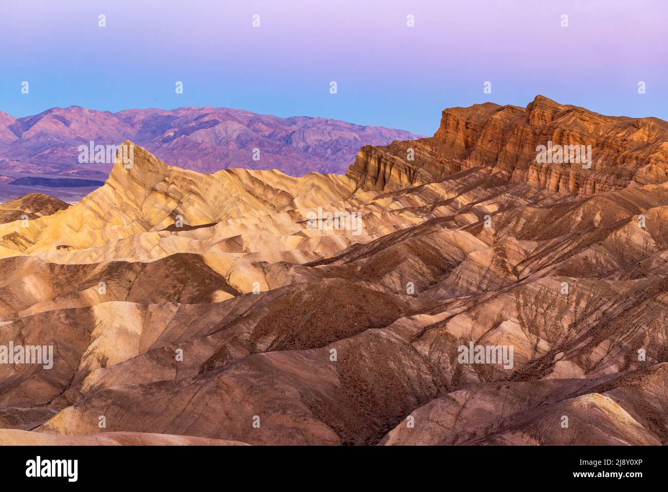 Badlands and the Panamint Range lit up with soft early morning light at Zabriske Point in Death Valley National Park, California. Stock Photo