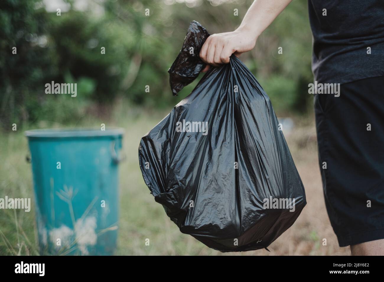 hand holding a garbage bag and are being dropped into the trash Stock
