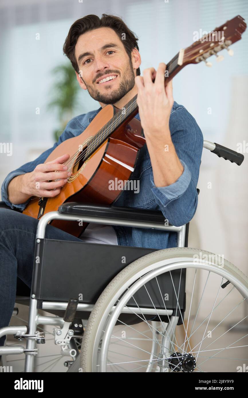 man on the wheelchair playing the guitar Stock Photo Alamy