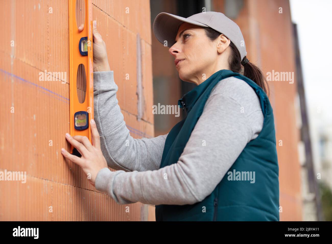 female apprentice builder with spirit level Stock Photo