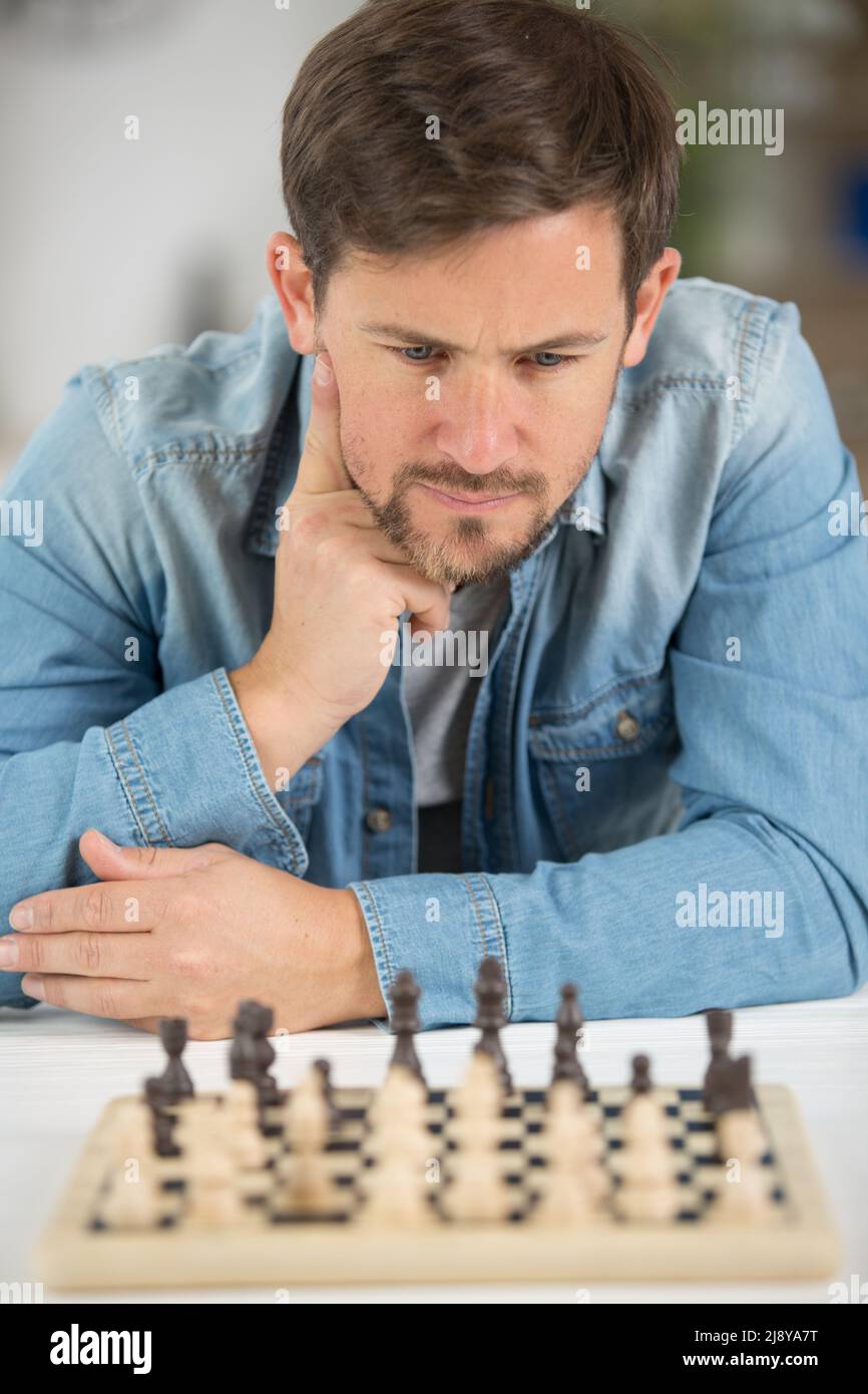 man studying the next chess move Stock Photo - Alamy