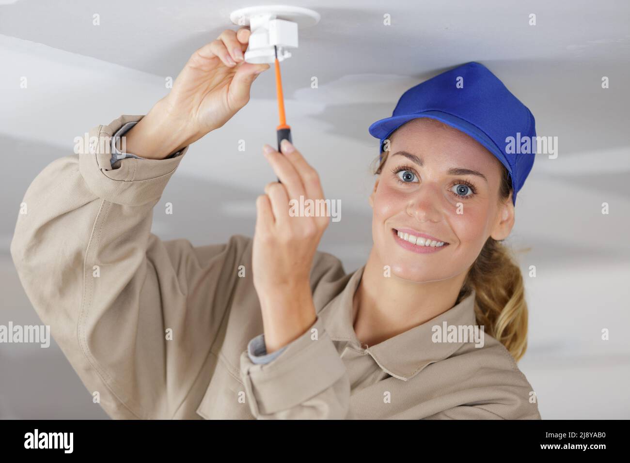 female electrician working on light fitting Stock Photo Alamy