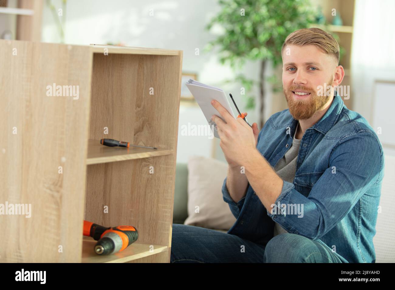 furniture assembly worker assembles bookshelf Stock Photo Alamy