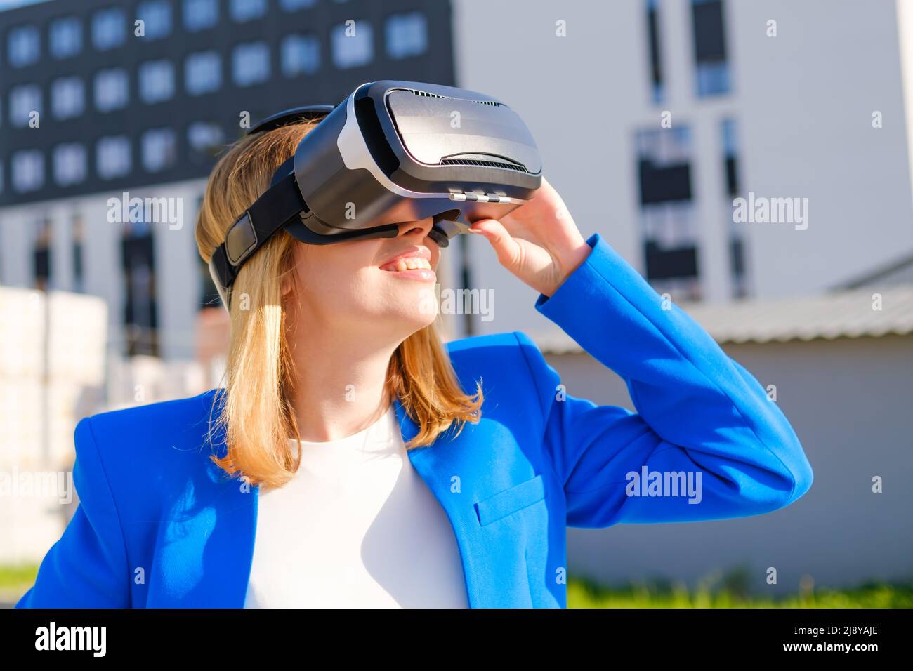 Smiling woman in vr glasses experiencing augmented reality in front of ...