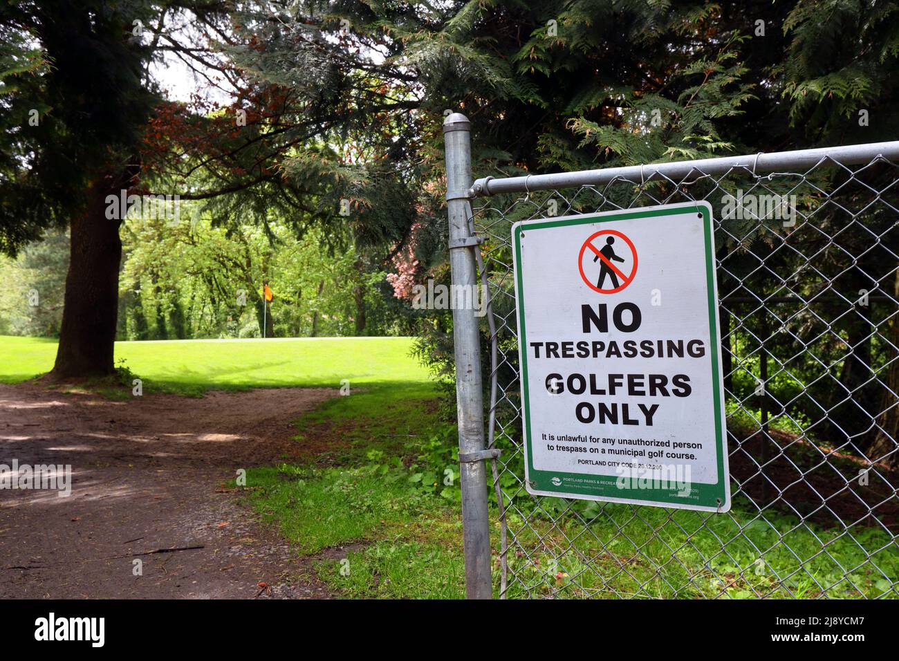 A 'No Trespassing Golfers Only' sign at Eastmoreland Golf Course, Portland, Oregon. The sign cites Portland city code 20.12.200 Stock Photo