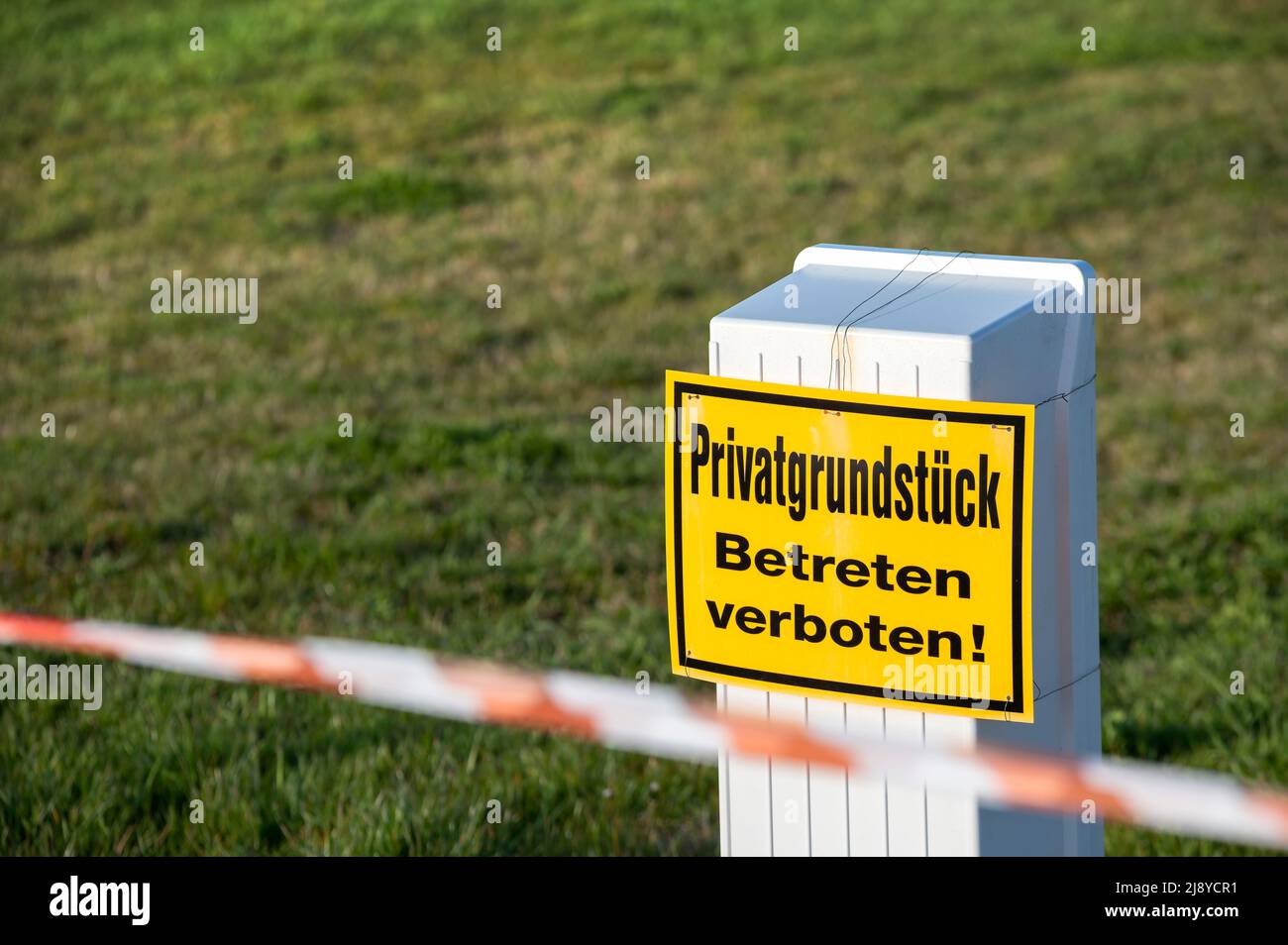 Barricaded construction site with a warning sign with the text 'private property - no trespassing!' in German language Stock Photo