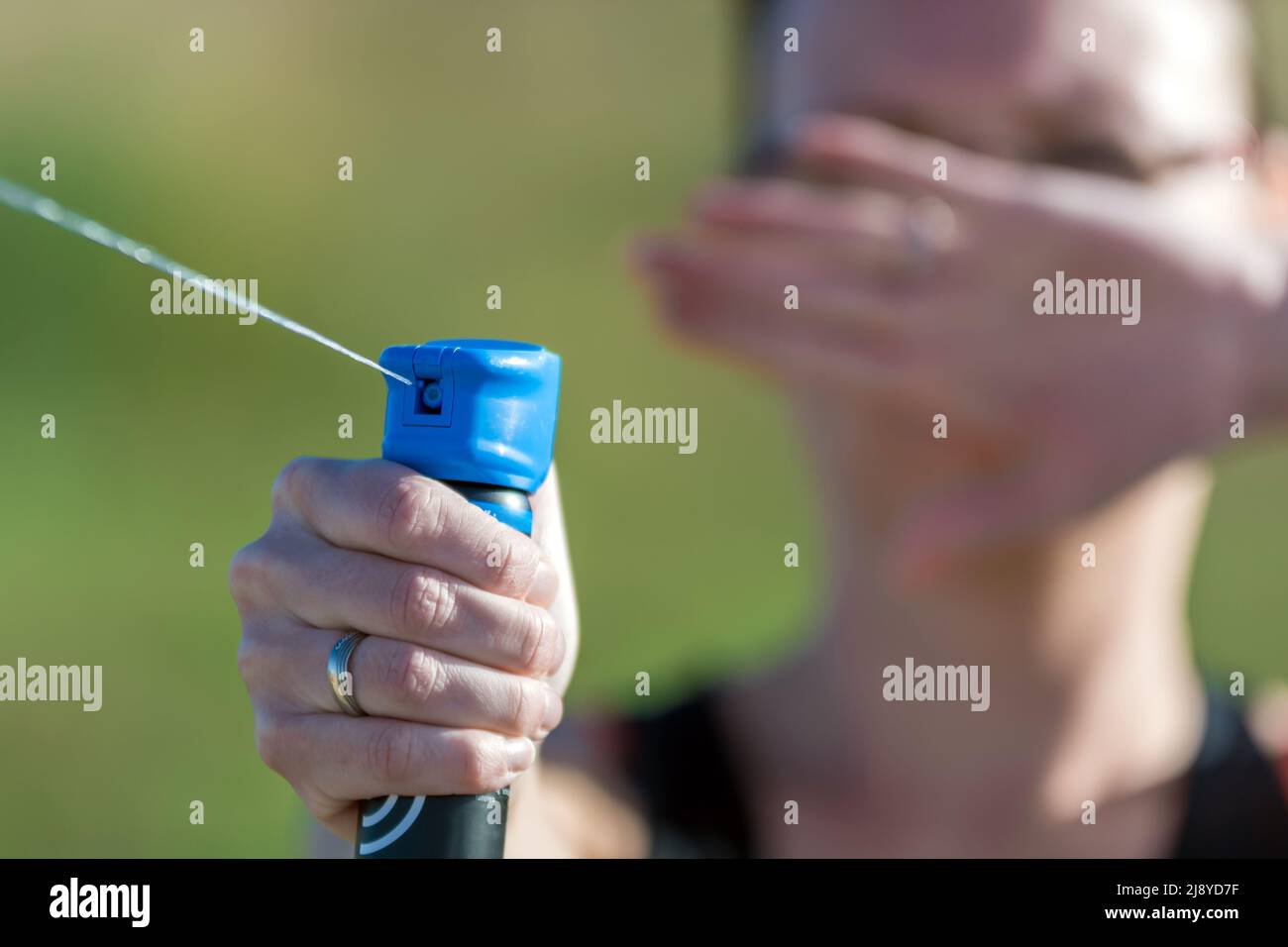 Woman defends herself with pepper spray against attacker Stock Photo