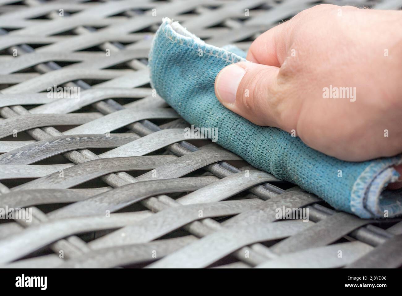 Care of rattan furniture in the garden with a damp cloth Stock Photo