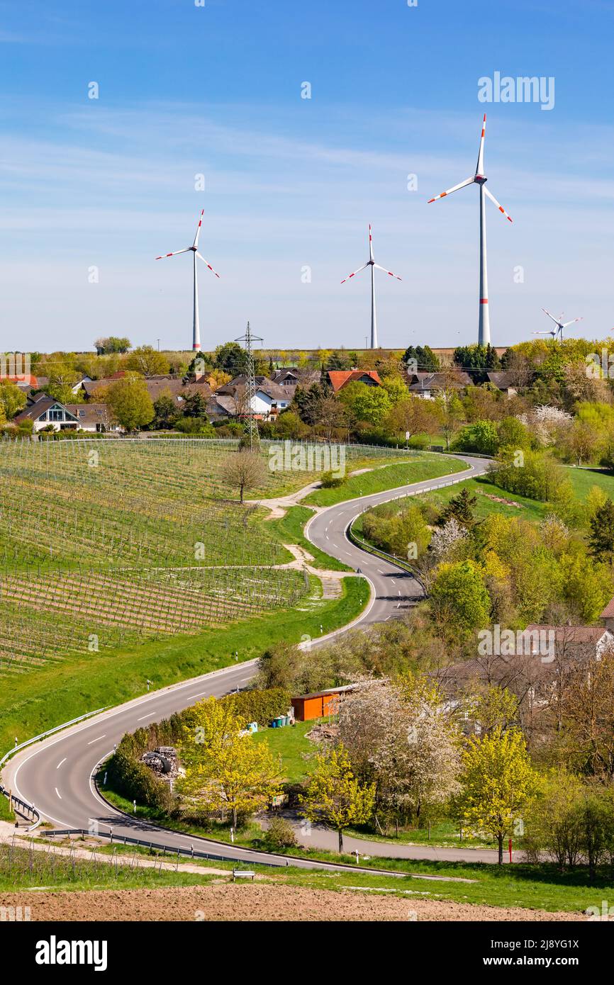 Winding road leading to a rural settlement dominated by wind turbines in Germany Stock Photo