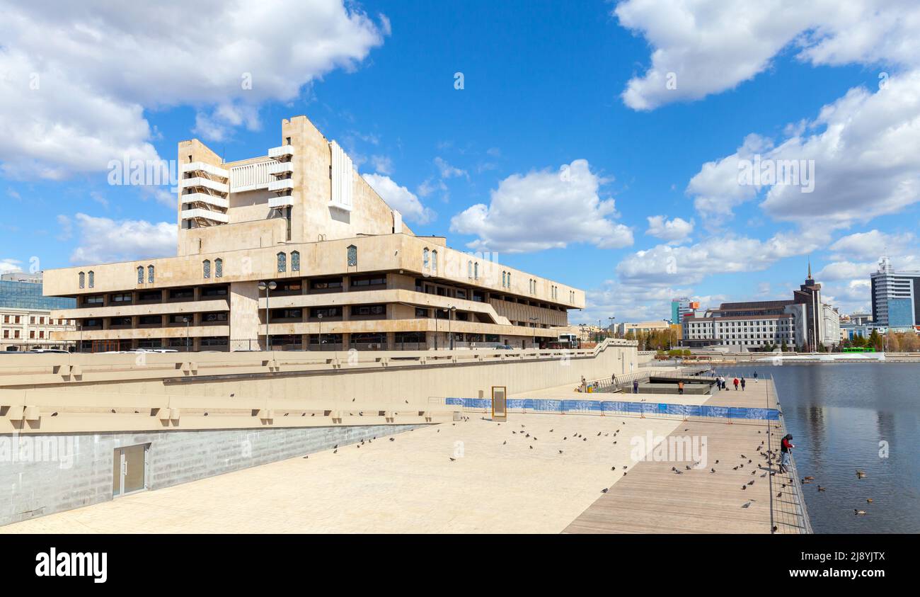 Kazan, Russia - May 6, 2022: Galiaskar Kamal Tatar Academic Theatre exterior. Street view with ordinary people at the coast of Lake Kaban Stock Photo
