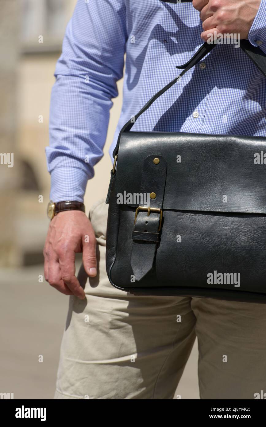 Part photo of a man with a black leather briefcase with antique and