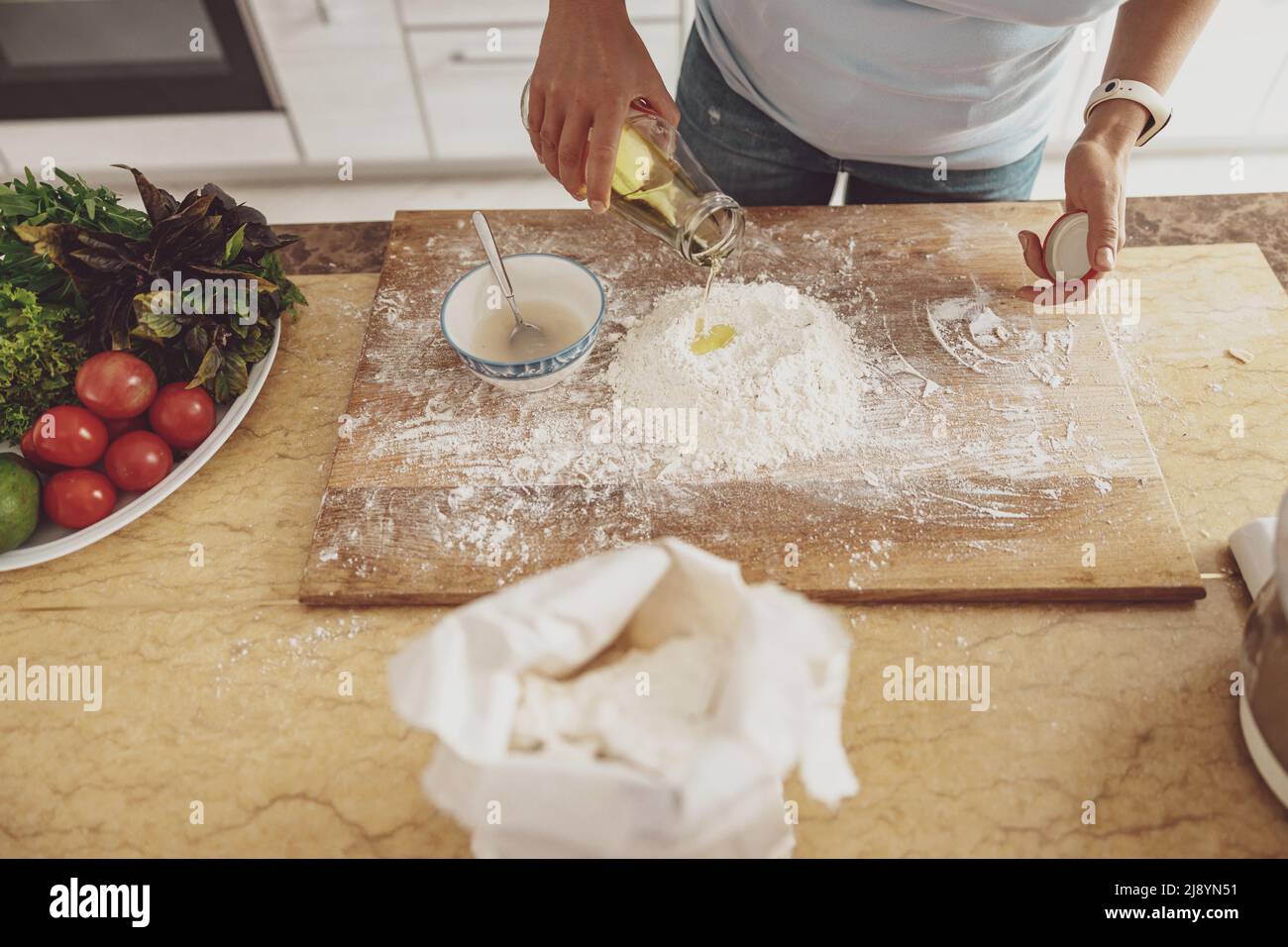 Preparation for kneading pizza dough with the addition of olive oil to