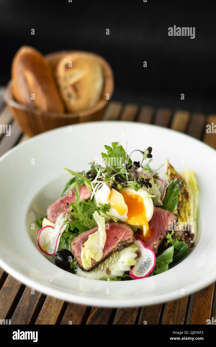 nicoise salad with fresh seared tuna and boiled egg on wood table Stock Photo
