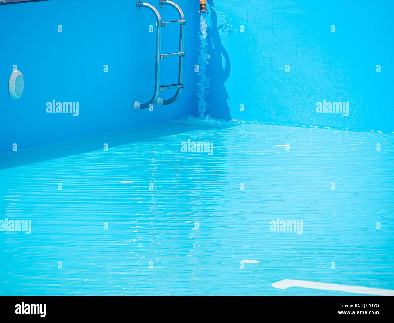 Pouring fresh water into swimming pool. Clear blue water refreshing