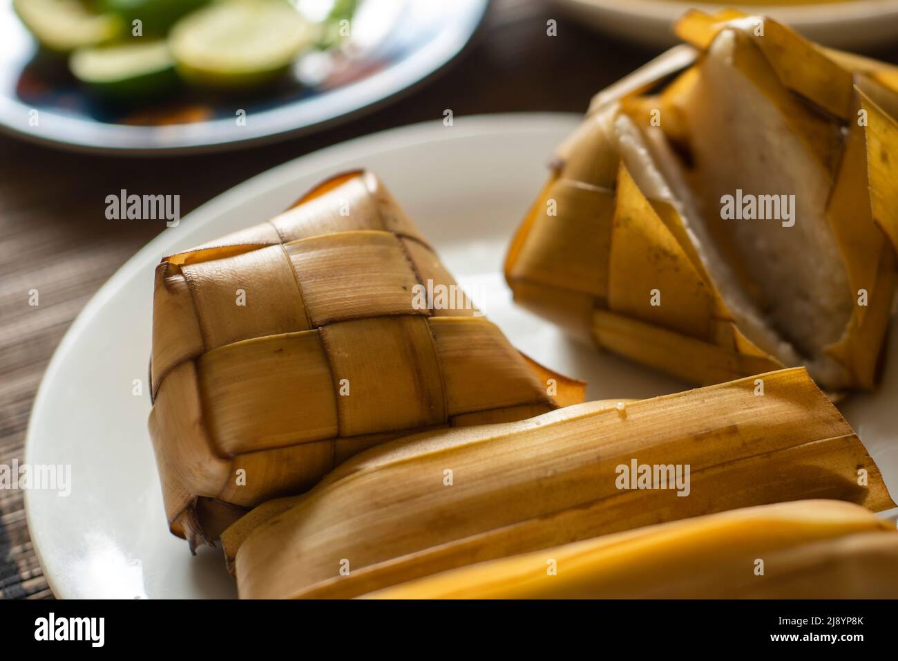 Rice cake (Ketupat) is Cooked Rice packed inside a diamond-shaped container of woven palm leaf pouch for Moslem Celebration. Eid Mubarak concept. Indo Stock Photo