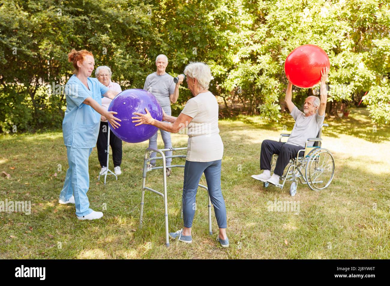 Group of seniors with disabilities do exercise with gymnastic ball for