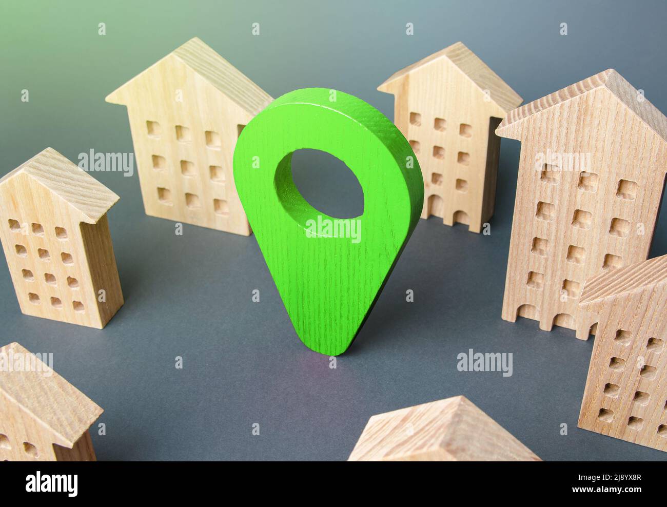 Green location indicator among houses. Delivery. Tracking and navigation. Internet of things, city management and city services municipal. Business ad Stock Photo