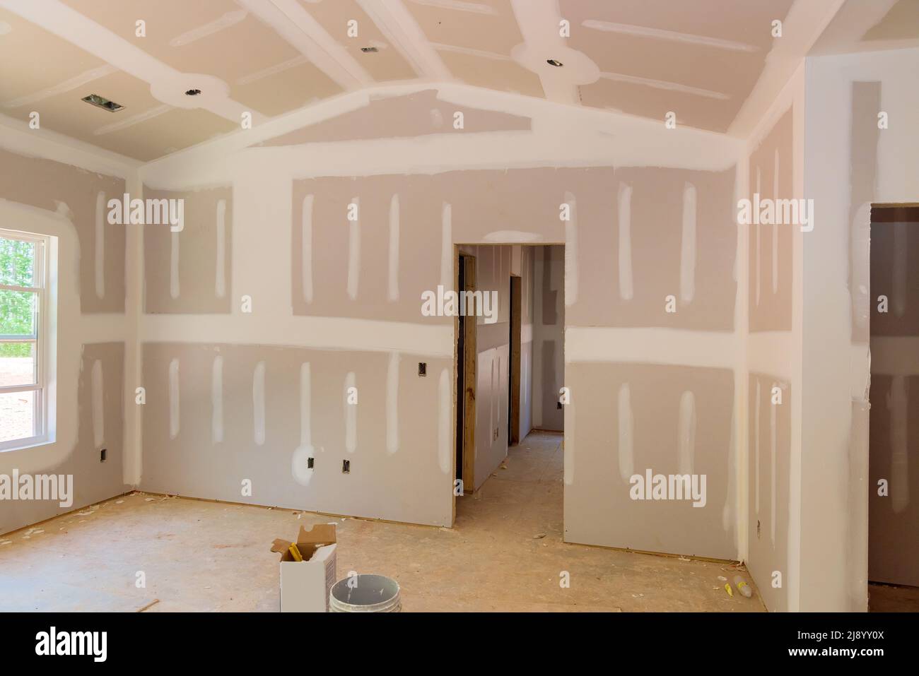 Finishing plastering drywall in ready for paint with new house Stock