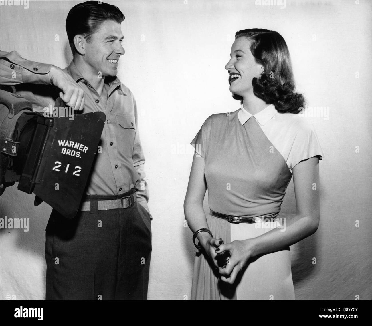 Actor and President of the Screen Actors' Guild RONALD REAGAN on set candid at Warner Bros. Burbank Studio with set visitor new Canadian Contract Player LOIS MAXWELL during filming of THE VOICE OF THE TURTLE 1947 director IRVING RAPPER play / screenplay John Van Druten Warner Bros. Stock Photo