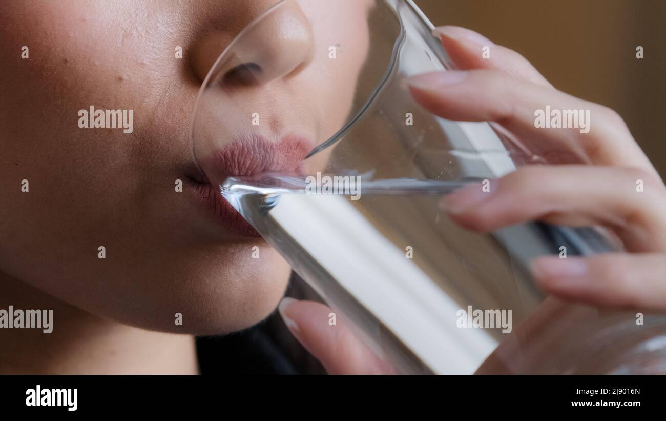 Closeup female lips unrecognizable woman drinking clean water home delivery holding glass lunch morning daily ritual good habit girl feeling thirsty h Stock Photo