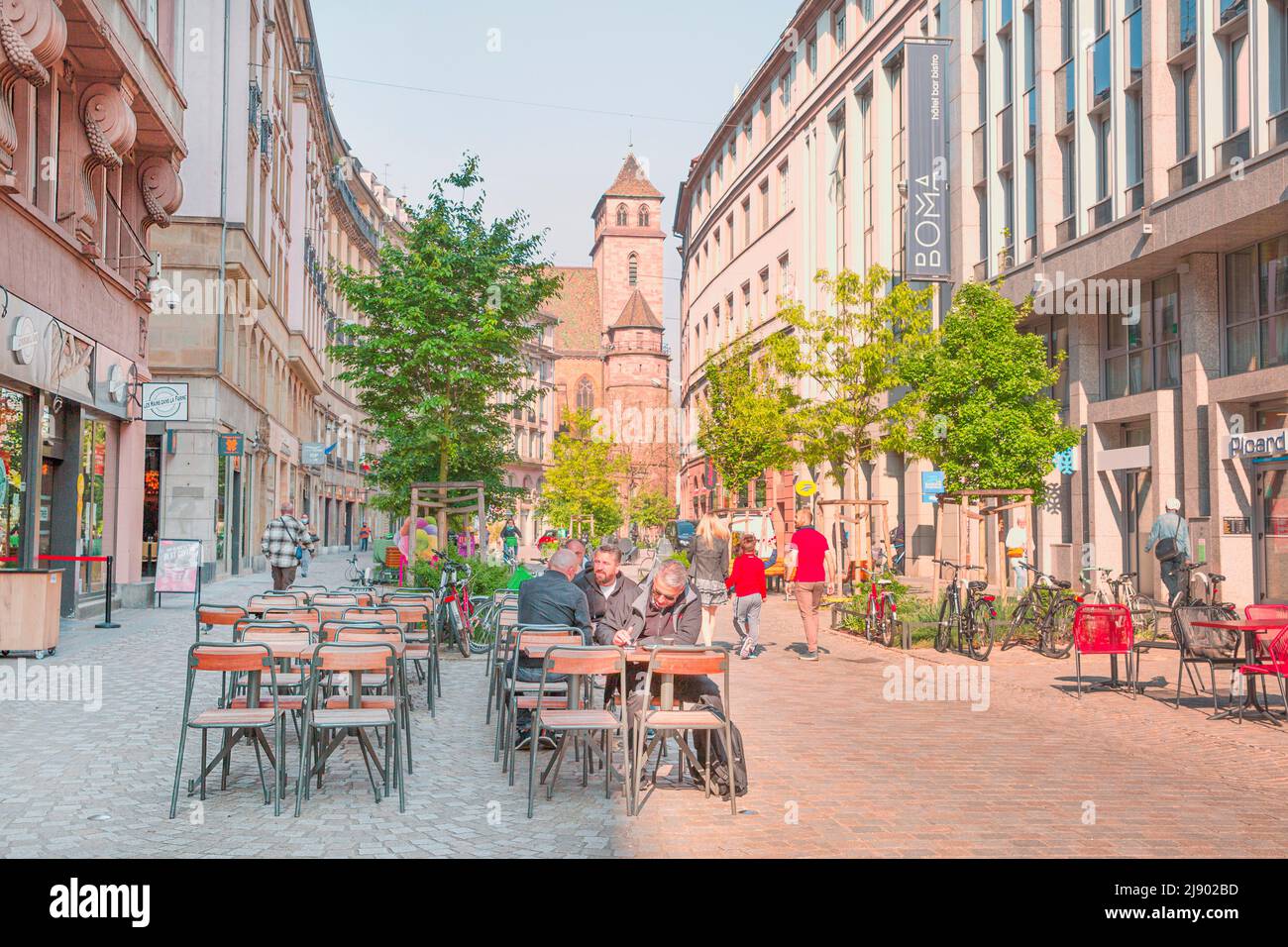 2 of May 2022, Strasbourg, France. Saint Thomas church and people, sitting in the restaurant. Stock Photo