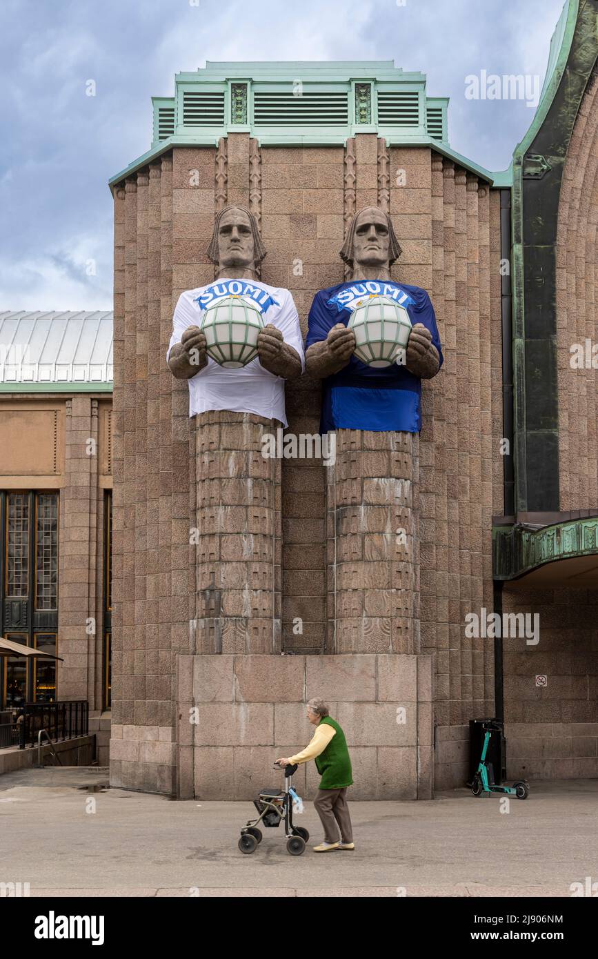 Large stone statues wearing Team Finland Ice Hockey jerseys in front of Helsinki railway station Stock Photo