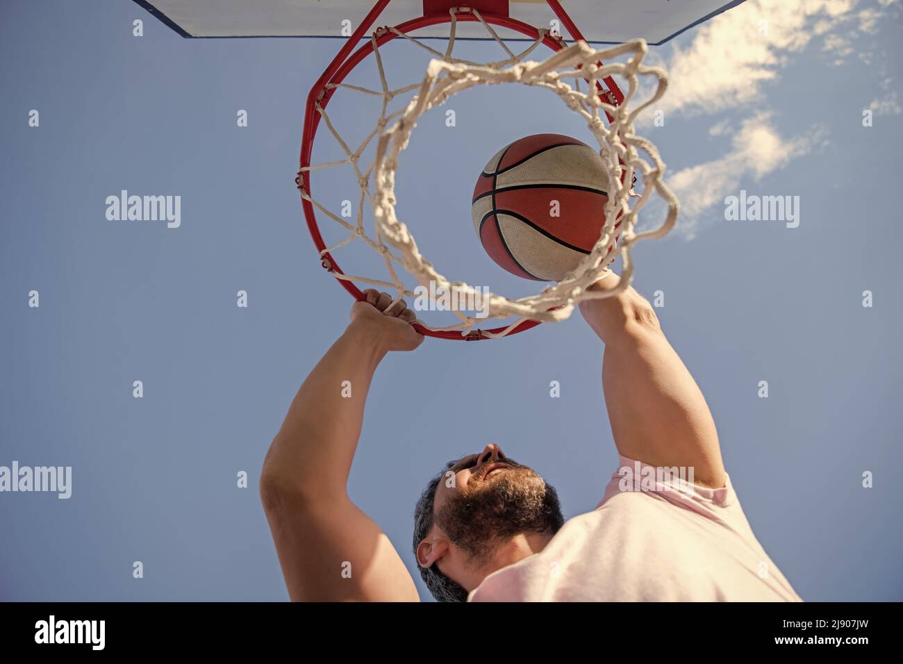 basketball player throws the ball into the hoop outdoor, targeting