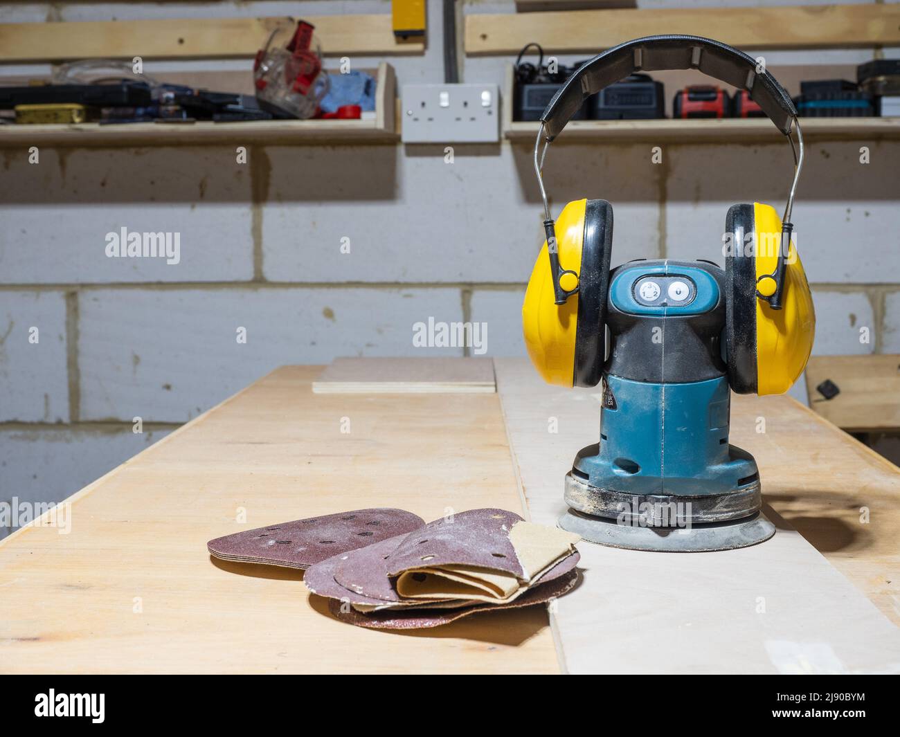 Cordless battery operated orbital sander with ear defenders Stock Photo