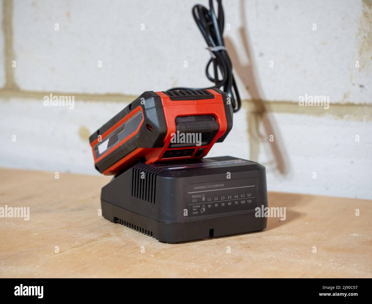 Lithium ion battery docked in charger unit connected to mains power Stock Photo