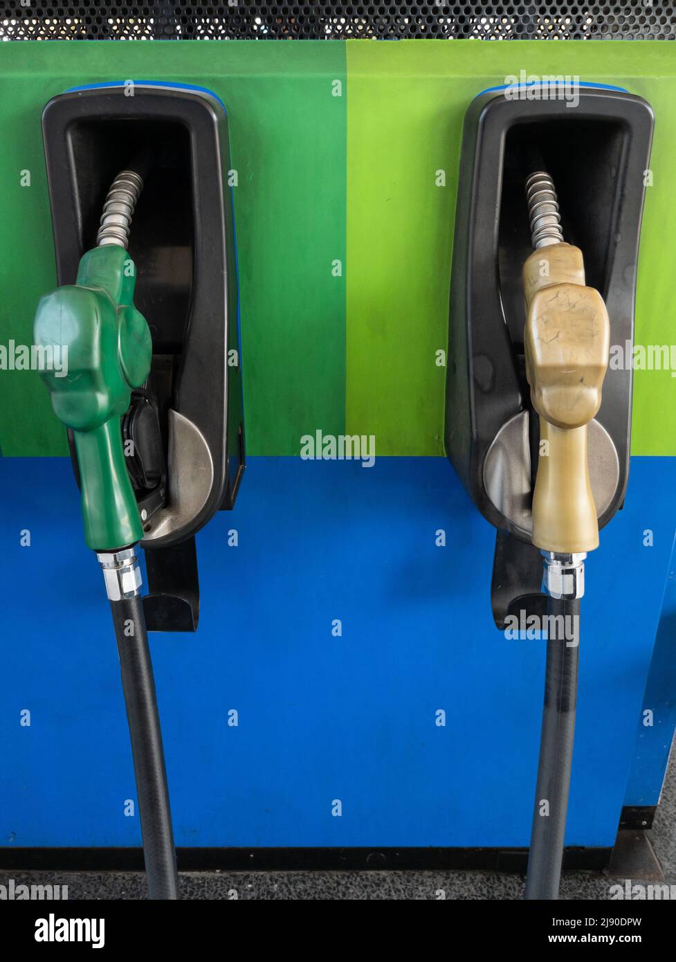 A couple of fuel nozzles in the gas station located near the highway in the rural area, front