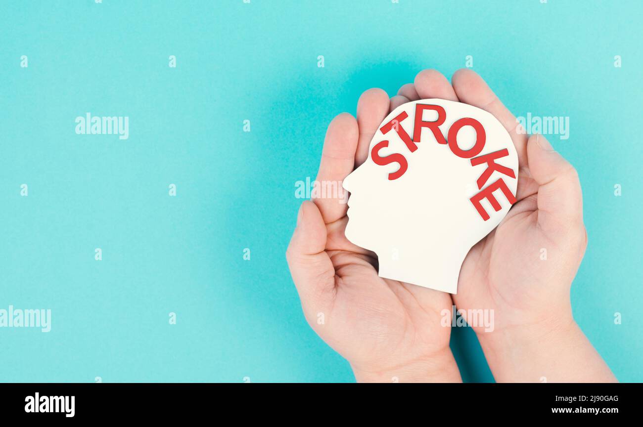 Holding a head with the word stroke in the hand, brain injury, ischemic and hemorrhagic types, health care Stock Photo