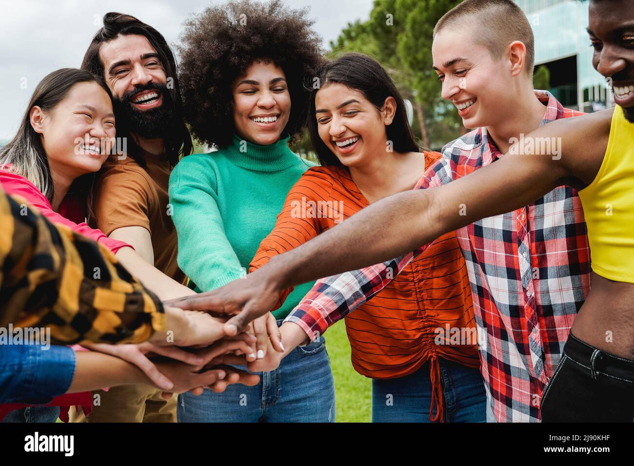 Young multiethnic group of people stacking hands together outdoor - Teamwork diversity and unity concept Stock Photo
