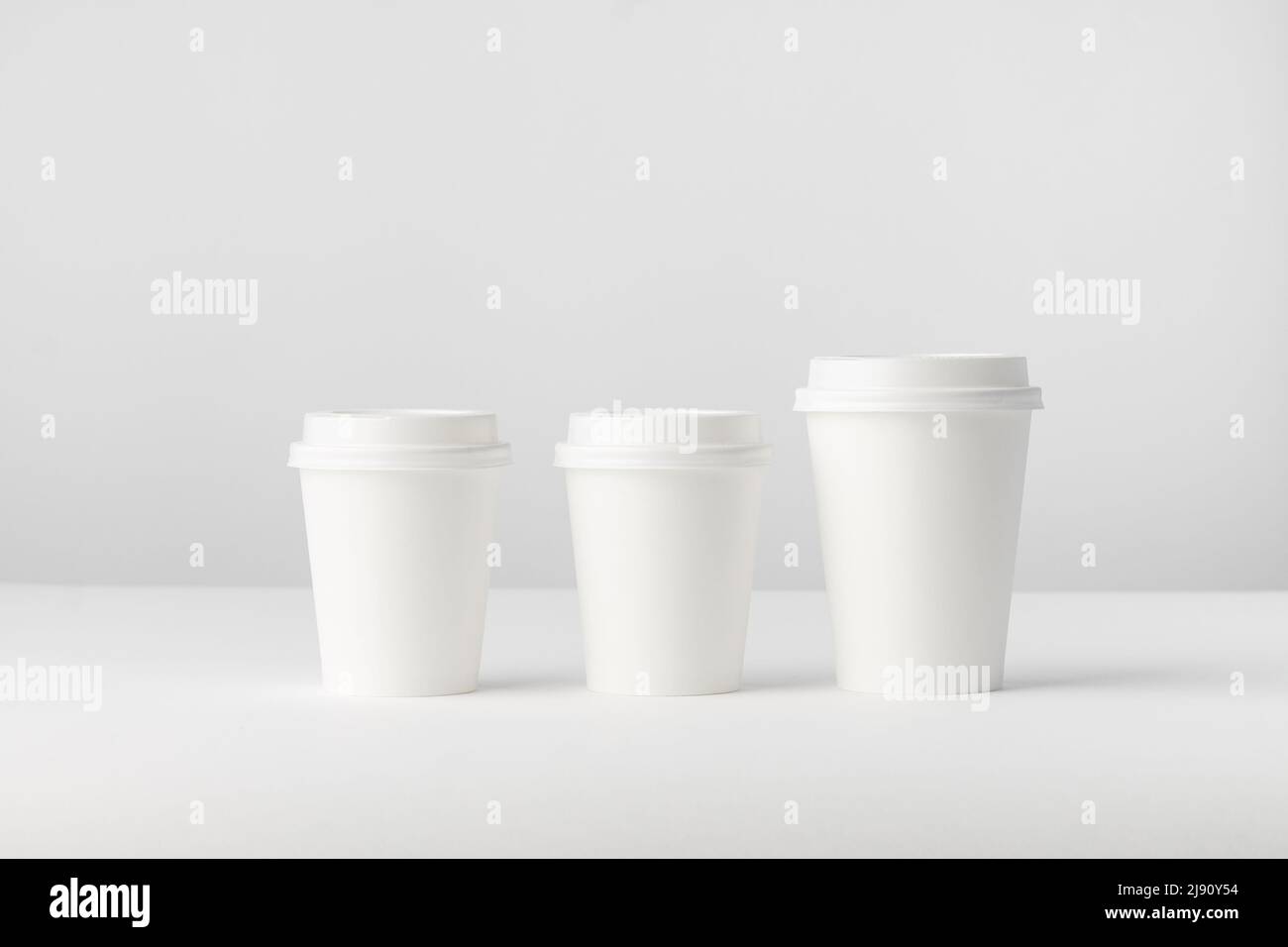 Three white paper Coffee Cups on a white background Stock Photo - Alamy