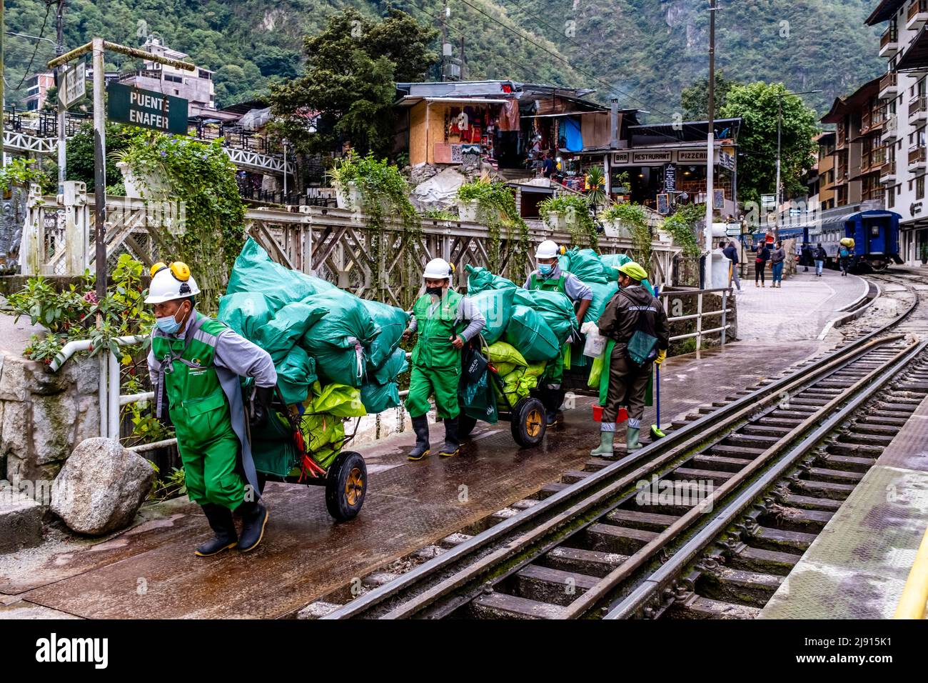 Peruvian Environmental Workers Transporting Goods From The Train Station In Aguas Calientes, Cusco Region, Peru. Stock Photo