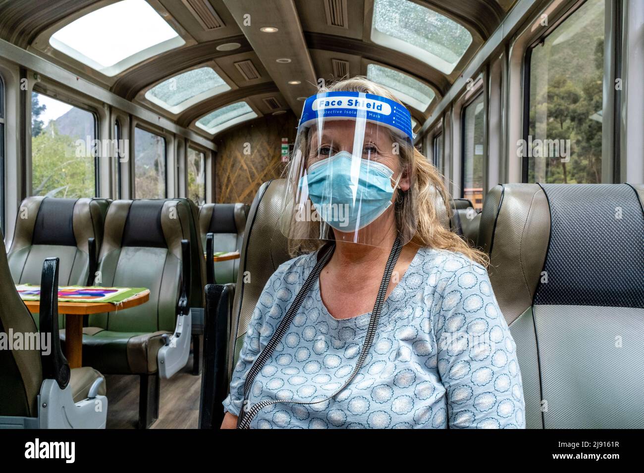 A Mature Woman On Board An Empty Perurail Train Travelling Between Ollantaytambo and Aguas Calientes Stations During The Covid 19 Pandemic, Peru. Stock Photo