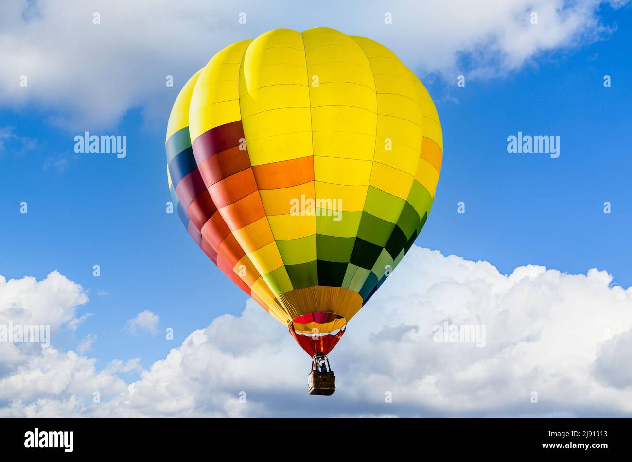 Colorful hot air balloon flying over blue sky Stock Photo - Alamy