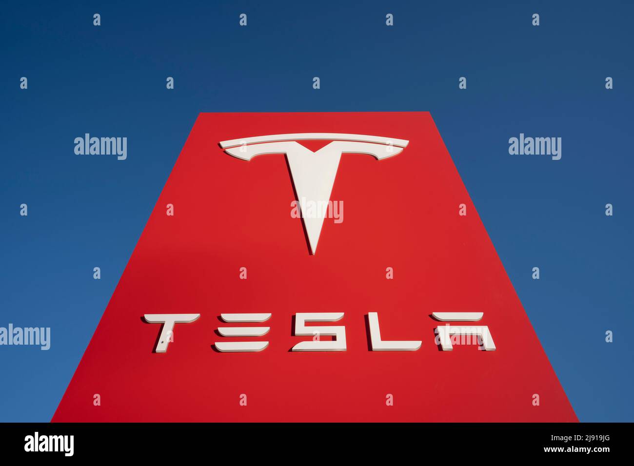 Closeup of a Tesla sign seen outside a Tesla showroom in Sunnyvale, California, isolated against a clear blue sky, on May 3, 2022. Stock Photo