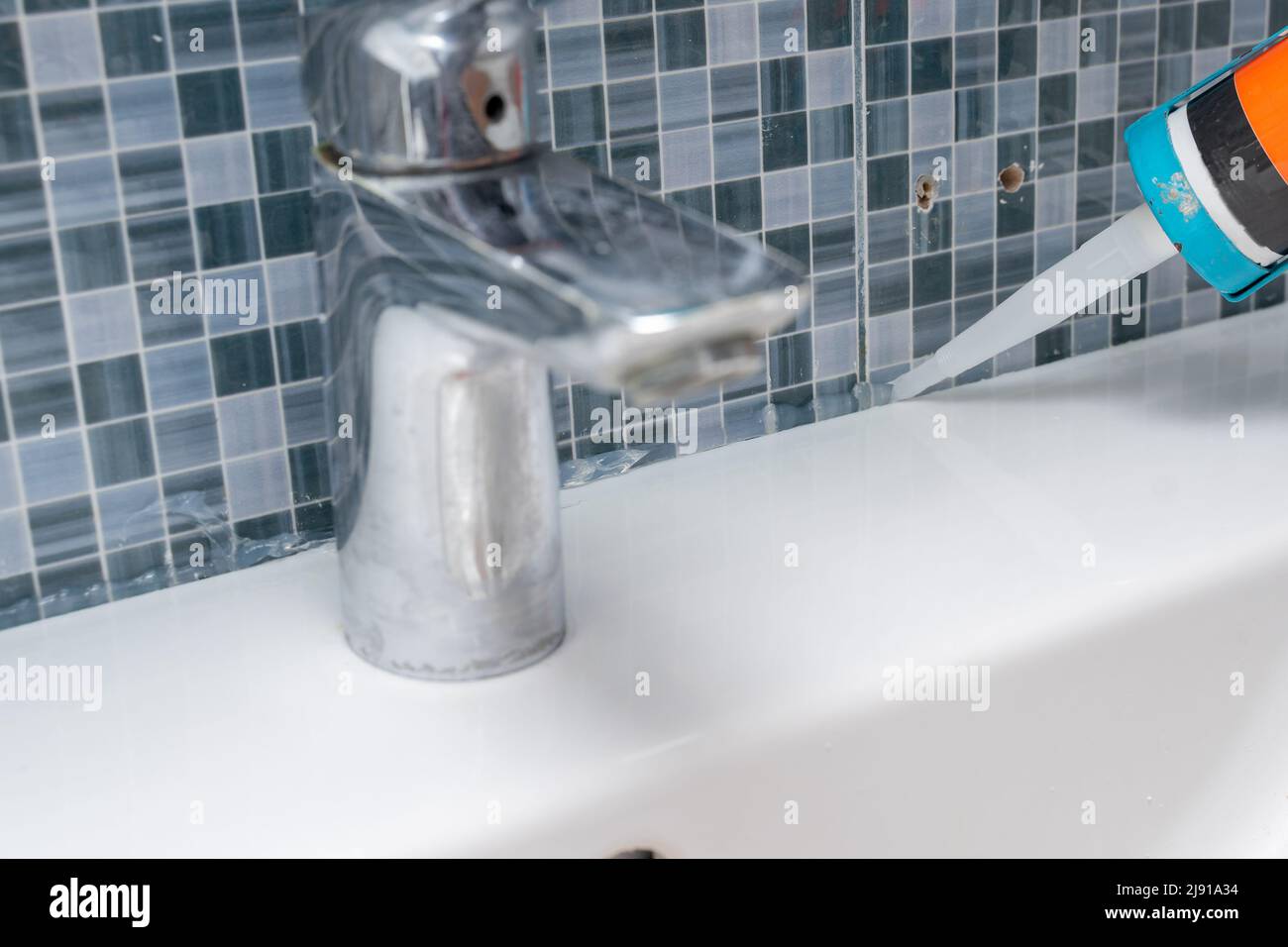 the master seals the seams of the junction of tiles and sinks in the