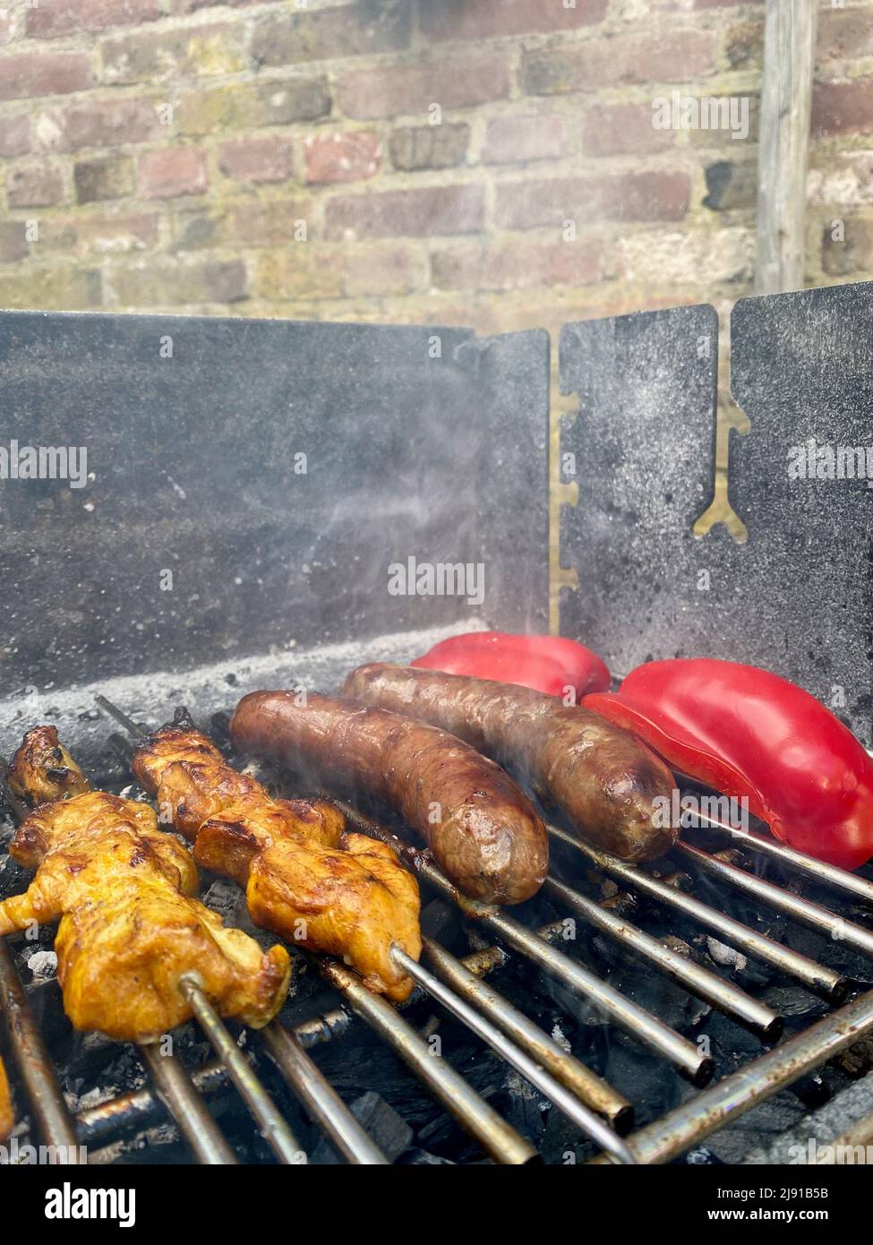 Barbecue BBQ of smoked grilled sausage bangers, meat satay on sticks
