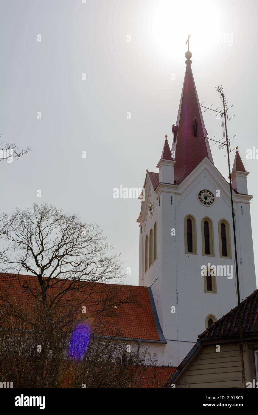 Red Gothic spire of the the massive white bell-tower of St. John’s Church in Cesis, Latvia Stock Photo