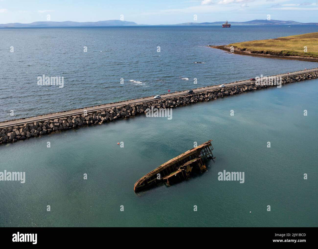 Aerial view of Churchill Barrier No.3 and 'block ship' partially submerged. The barrier links Glimps Holm and Burray, Orkney Islands, Scotland Stock Photo