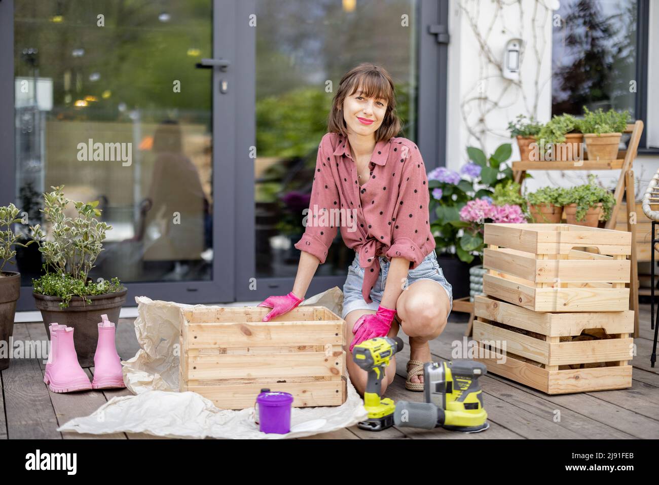 Housewife repairs wooden boxes on terrace Stock Photo Alamy