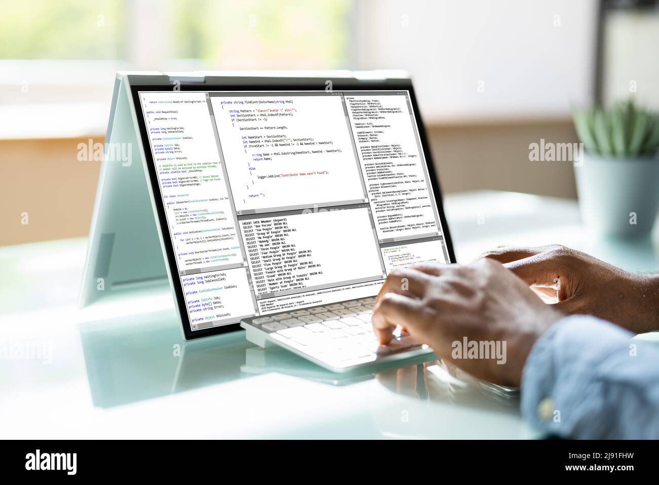 Programmer Or Coder At Office Desk Using Laptop Stock Photo
