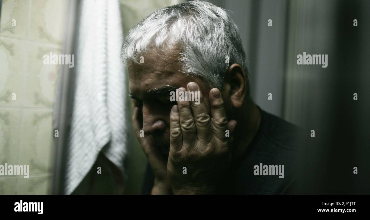 Worried old man with anxiety covering face with hand Stock Photo - Alamy