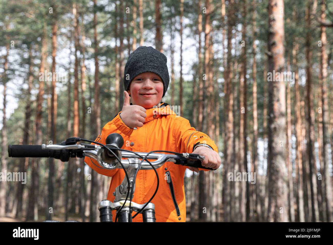 happy preschooler rides a bicycle through the park on a bike path  Stock Photo