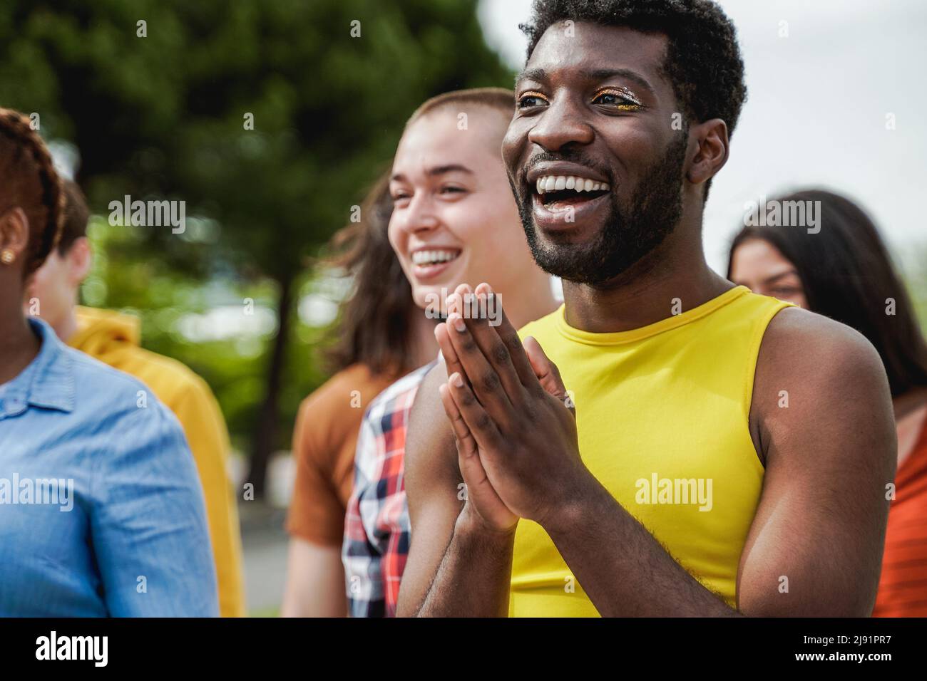 Multiethnic diverse people celebrating together outdoor at pride event - Focus on gay african man with make-up Stock Photo